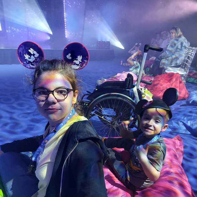 Lincoln and his sister, wearing their Mickey ears, with front row seats to a show during his wish.