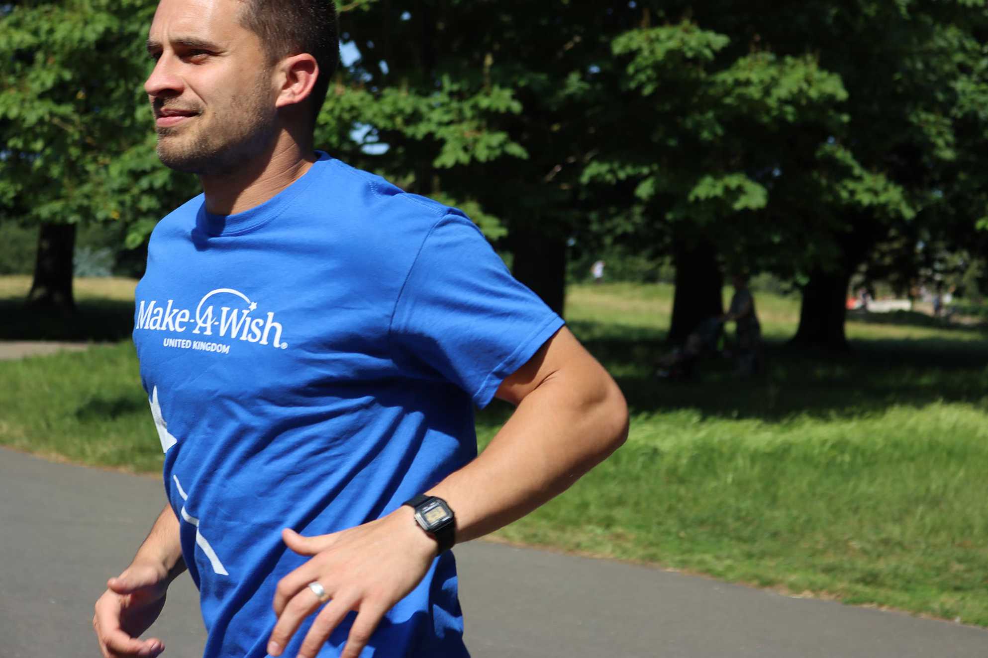 A supporter running in a blue Make-A-Wish t-shirt.