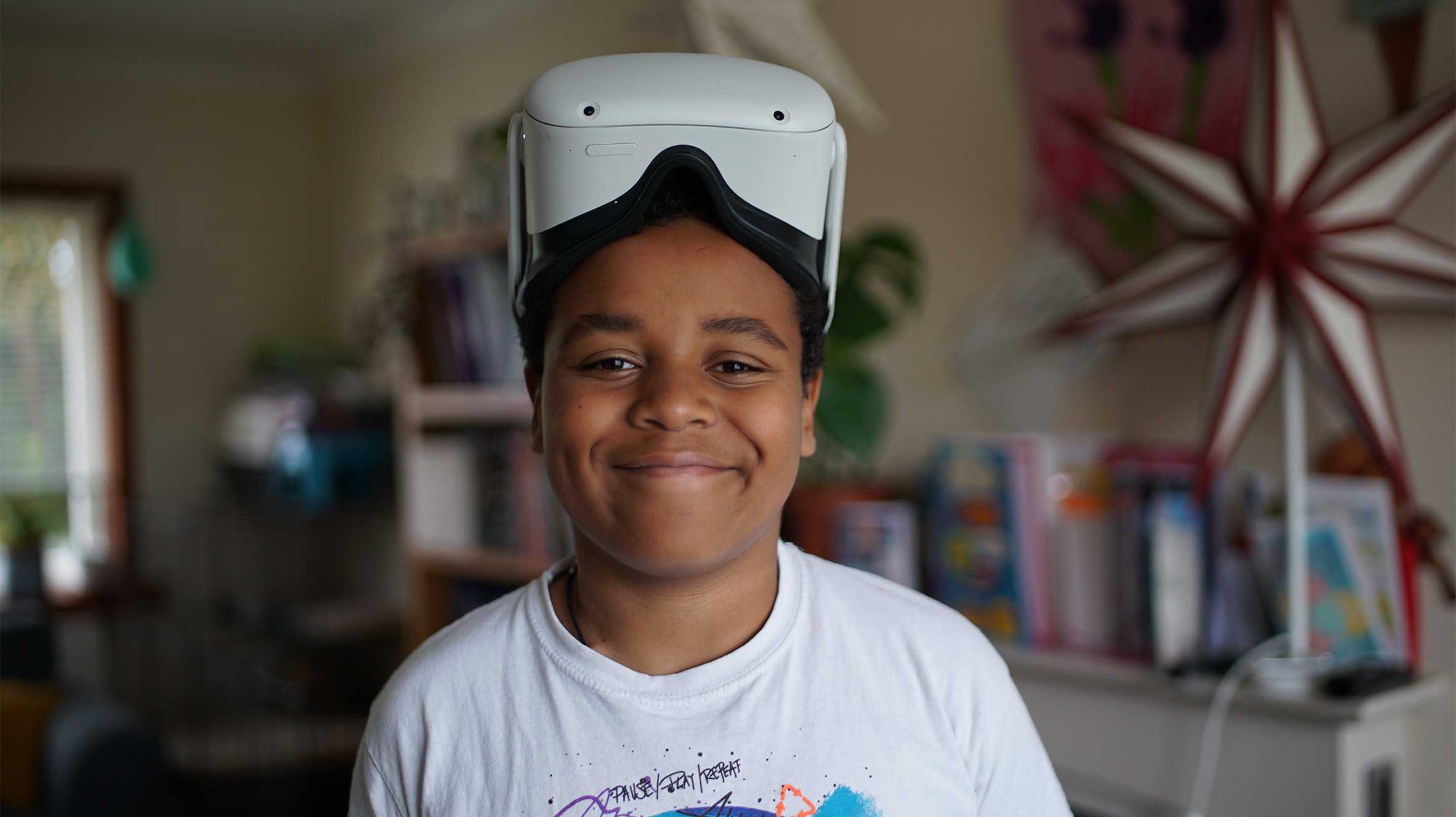 Lukasz, smiling with his VR headset on top of his head.