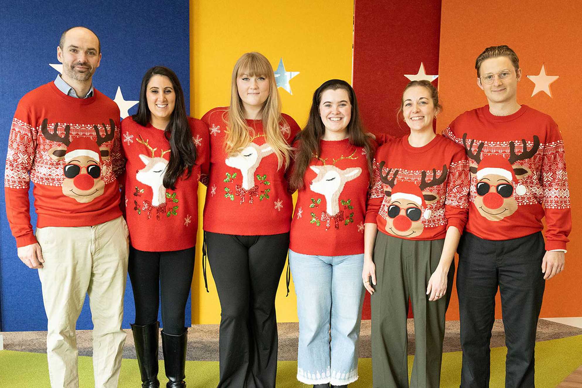 Six member of the Make-A-Wish team modelling Peacock's 2023 Christmas jumpers.